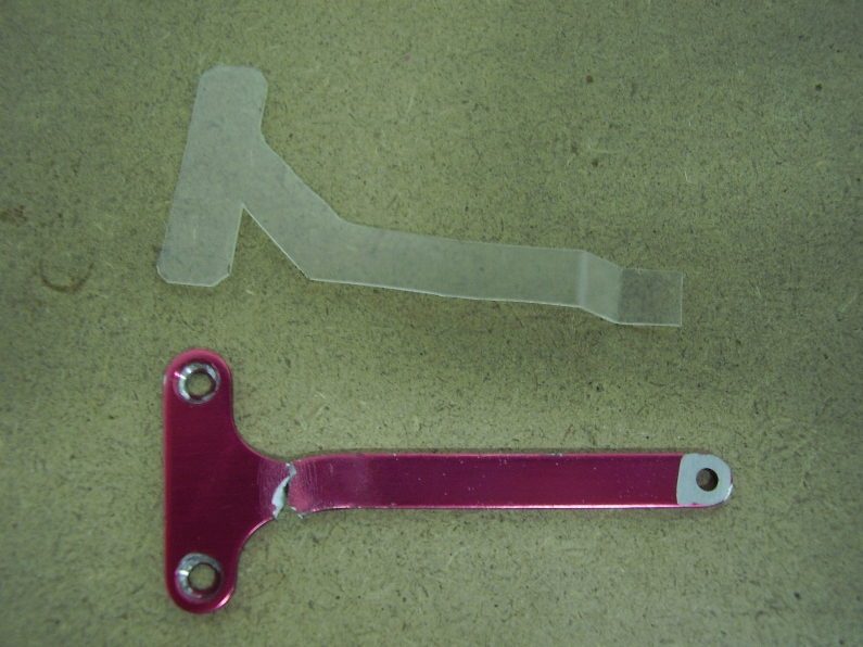 Puntone
Il puntone originale, quello rosso, si è spezzato nel tentativo di modificarlo, abbassando il motore il carburatore andava a toccare su di esso, in lexan, il prototipo del nuovo puntone, poi rifatto in alluminio sp 2mm.